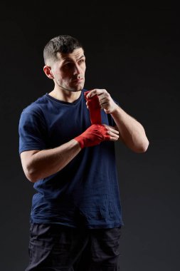 Düşük anahtar stüdyo portre yakışıklı kaslı dövüşçülerin korku koyu arka plan bulanık boks için hazırlanıyor