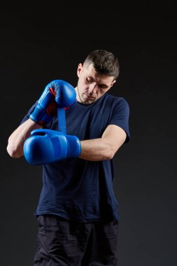 Düşük anahtar stüdyo portre yakışıklı kaslı dövüşçülerin korku koyu arka plan bulanık boks için hazırlanıyor