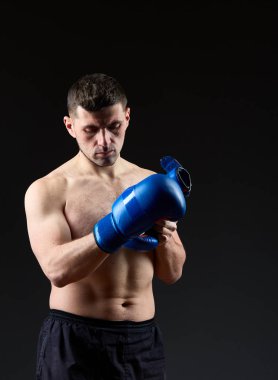 Düşük anahtar stüdyo portre yakışıklı kaslı dövüşçülerin korku koyu arka plan bulanık boks için hazırlanıyor