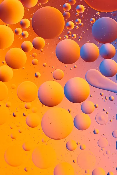 Mixing water and oil, beautiful color abstract background based on red and yellow circles and ovals, macro abstraction
