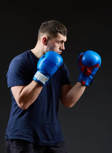 Estudio de bajo perfil retrato de guapo luchador muscular preparándose para el boxeo sobre fondo oscuro borroso —  Fotos de Stock