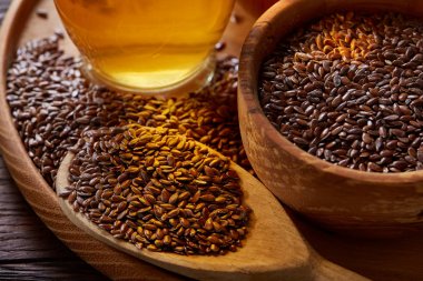 Ahşap arka plan, üstten görünüm, yakın çekim, seçici odak cam şişede kase ve keten tohumu yağı keten tohumu