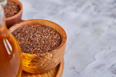 Beyaz arka plan, üstten görünüm, yakın çekim, seçici odak cam şişede kase ve keten tohumu yağı keten tohumu