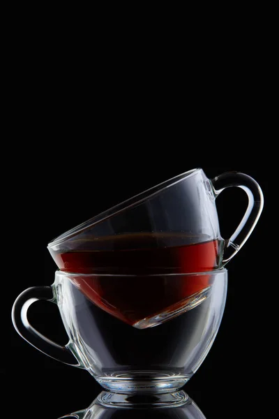 Composition conceptuelle de deux tasses en verre sur fond rouge coloré, gros plan, vertical . — Photo