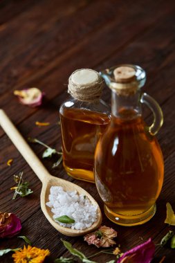 Spa Konsept: kaplıca tedavisi doğal deniz tuzu, aromatik yağ ve çiçeklerle ahşap arka plan üzerinde bileşimi