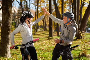 Mutlu genç çift için bir bisiklet mi parkta bir sonbahar gününde binmek.