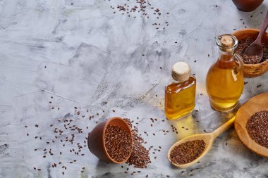 Işık cam şişede kase ve keten tohumu yağı keten tohumu dokulu arka plan, üstten görünüm, yakın çekim, seçici odak