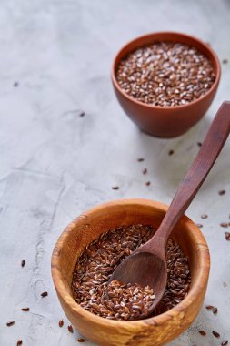 Işık cam şişede kase ve keten tohumu yağı keten tohumu dokulu arka plan, üstten görünüm, yakın çekim, seçici odak