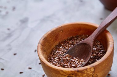 Işık cam şişede kase ve keten tohumu yağı keten tohumu dokulu arka plan, üstten görünüm, yakın çekim, seçici odak