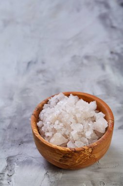 Büyük beyaz deniz tuzu bir doğal ahşap kase beyaz arka plan, üstten görünüm, yakın çekim, seçici odak