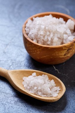 Büyük beyaz deniz tuzu koyu arka plan, üstten görünüm, yakın çekim, seçici odak bir doğal ahşap kase