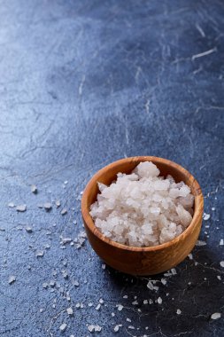 Büyük beyaz deniz tuzu bir doğal ahşap kase beyaz arka plan, üstten görünüm, yakın çekim, seçici odak