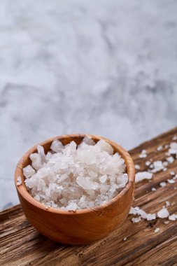 Büyük beyaz deniz tuzu bir doğal ahşap kase beyaz arka plan, üstten görünüm, yakın çekim, seçici odak