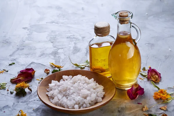 Composition of spa treatment on white background. Sea salt and flowers background, close up, top view, selective focus.
