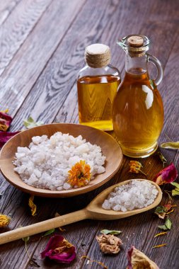 Spa Konsept: kaplıca tedavisi doğal deniz tuzu, aromatik yağ ve çiçeklerle ahşap arka plan üzerinde bileşimi
