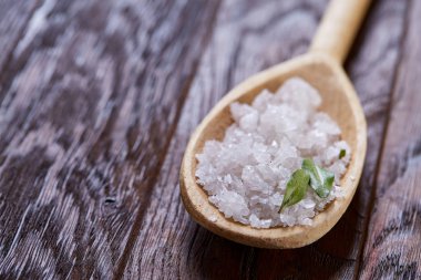 Spa Konsept: kaplıca tedavisi doğal deniz tuzu, aromatik yağ ve çiçeklerle ahşap arka plan üzerinde bileşimi