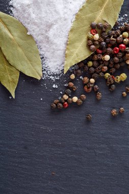 Bay defne yaprak biber ve tuz izole koyu arka plan, üstten görünüm, yakın çekim, seçici odak bileşimi