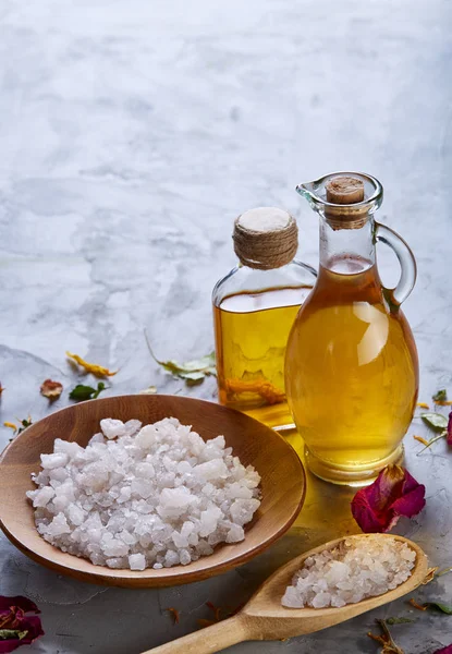 Composition of spa treatment on white background. Sea salt and flowers background, close up, top view, selective focus.