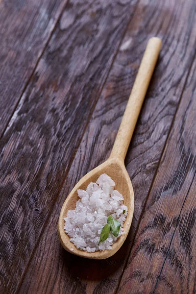 Sal marina cristalina en una cuchara de madera sobre fondo de madera oscura vintage, vista superior, primer plano, enfoque selectivo . — Foto de Stock