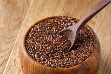 Linseeds bir rustik arka plan, yakın çekim, sığ alan, seçici odak derinliği ile devrilmiş bir ahşap kase