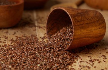 Linseeds bir rustik arka plan, yakın çekim, sığ alan, seçici odak derinliği ile devrilmiş bir ahşap kase