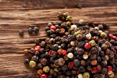 Siyah, kırmızı ve beyaz karabiber ahşap arka plan üzerine sığ derinlik-in tarla izole üzerinde Üstten Görünüm.