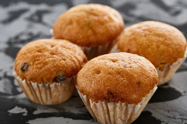 Lekkere muffins gerangschikt in patroon op licht gestructureerde achtergrond, close-up, ondiepe diepte van veld, selectieve aandacht. — Stockfoto