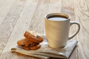 Rustik ahşap arka plan, üstten görünüm peçeteye pamuk üzerinde çerezleri porselen çay fincanı çikolata ile cips
