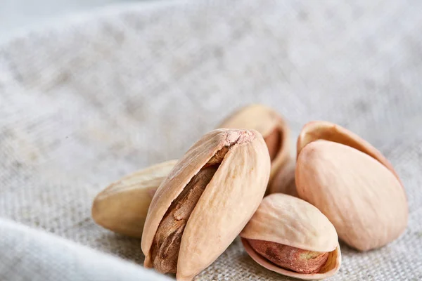 Pistachios on fabric cotton napkin, sallow depth of field, selective focus, top view, macro