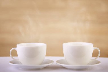 Temiz ve basit bir tasarım fikirleri, seçici odak iki beyaz porselen çay bardaklarından beyaz tablo göster