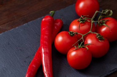 Domates grup ve acı biber siyah parça masa, üstten görünüm, yakın çekim.