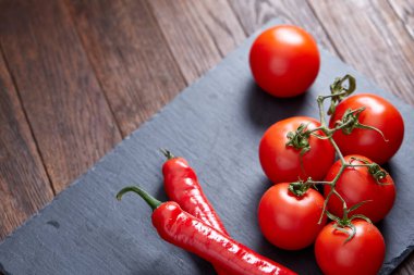 Kompozisyon kurulu, üstten görünüm, yakın çekim, seçici odak siyah parçası üzerinde acı biber ve domates grup.