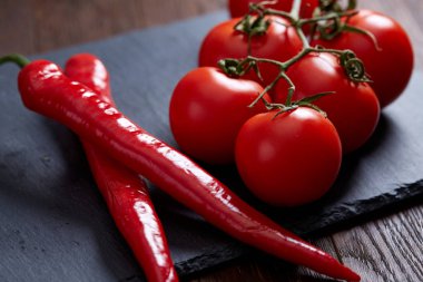 Kompozisyon kurulu, üstten görünüm, yakın çekim, seçici odak siyah parçası üzerinde acı biber ve domates grup.