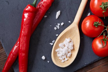 Taze üzüm domates, biber ve tuz ahşap zemin, seçici odak üzerine tahta kaşık ile vejetaryen natürmort