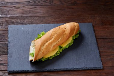 Peynir ve kesme tahtası ahşap arka plan, seçici odak üzerinde sebze taze ve lezzetli sandviç.