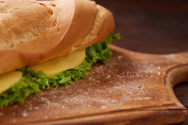 Peynir ve kesme tahtası ahşap arka plan, seçici odak üzerinde sebze taze ve lezzetli sandviç.