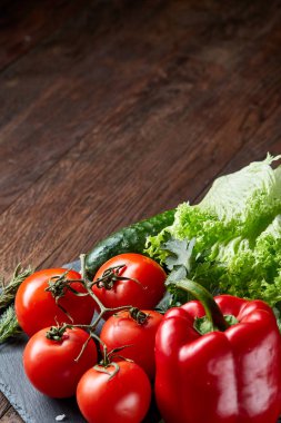 Vejetaryen natürmort çeşitli taze sebze ve otlar vintage ahşap arka plan, üstten görünüm, seçici odak.