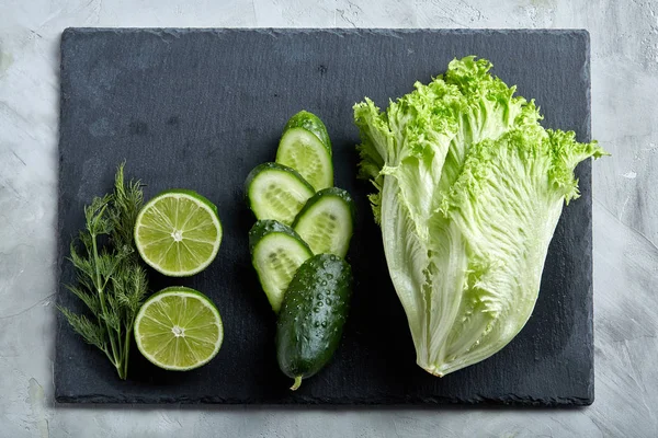 Concepto de lechuga verde fresca, pepino, eneldo, lima sobre un fondo claro, enfoque selectivo, vista superior, espacio para copiar . —  Fotos de Stock