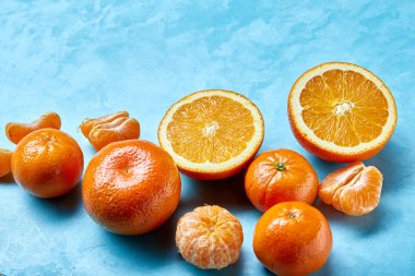 Taze narenciye meyve suyu ya da iki yüzlü yapmak mavi dokulu arka plan, üstten görünüm, seçici odak üzerinde çeşitli.