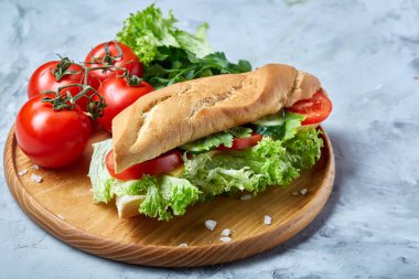 Marul, domates ve peynir ile taze sandviç ahşap beyaz dokulu arka plan üzerinde seçici odak tabakta