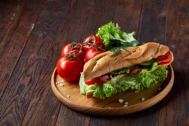 Marul, domates ve peynir ile taze sandviç ahşap ahşap arka plan üzerinde seçici odak tabakta