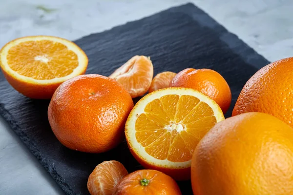 Taze mandalina ve turuncu masa, yakın çekim kesme üzerinde tam ve yarım kesilmiş