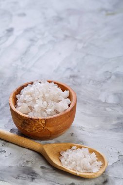 Kristal deniz tuzu bir tahta kaşık koyu arka plan, üstten görünüm, yakın çekim, seçici odak içinde.
