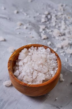 Büyük beyaz deniz tuzu bir doğal ahşap kase beyaz arka plan, üstten görünüm, yakın çekim, seçici odak