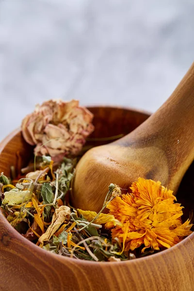 Wellness-Stillleben mit Blumen in Holzschale auf leicht strukturiertem Hintergrund, Draufsicht, Nahaufnahme, selektiver Fokus — Stockfoto