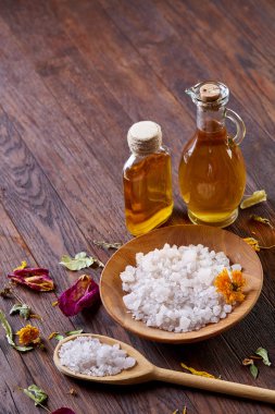 Spa Konsept: kaplıca tedavisi doğal deniz tuzu, aromatik yağ ve çiçeklerle ahşap arka plan üzerinde bileşimi