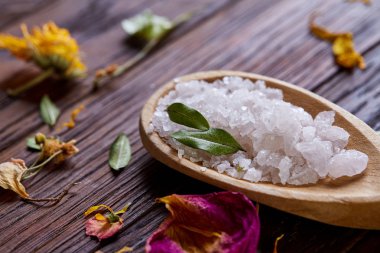 Spa Konsept: kaplıca tedavisi doğal deniz tuzu, aromatik yağ ve çiçeklerle ahşap arka plan üzerinde bileşimi