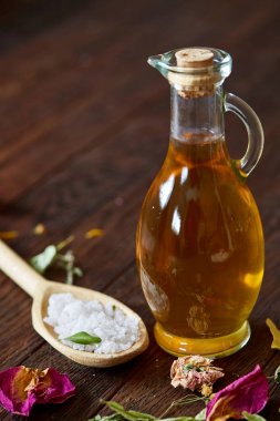 Spa Konsept: kaplıca tedavisi doğal deniz tuzu, aromatik yağ ve çiçeklerle ahşap arka plan üzerinde bileşimi