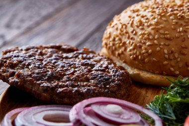 Lezzetli hamburger malzemeler sanatsal organize ahşap plaka, yakın çekim, en iyi görünüm, seçici odak