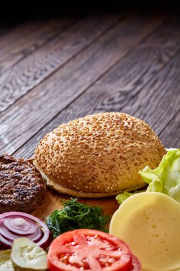 Lezzetli hamburger malzemeler sanatsal organize ahşap plaka, yakın çekim, en iyi görünüm, seçici odak